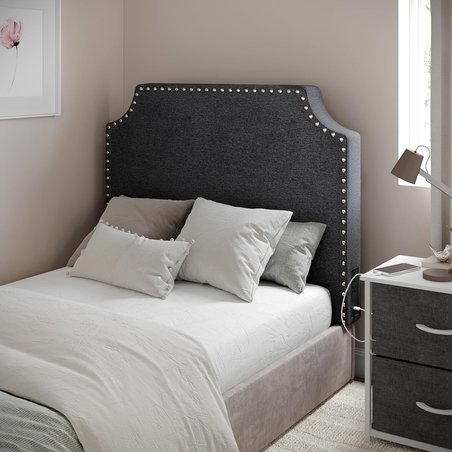 Grey studded upholstered headboard on a twin dorm bed with neutral bedding.