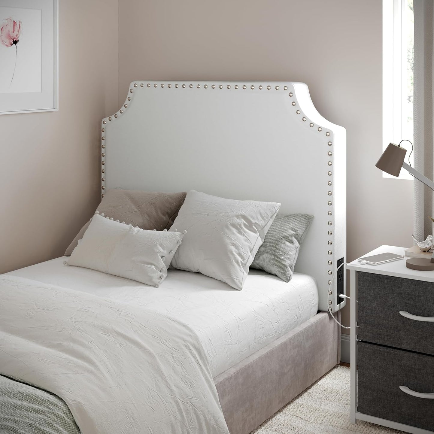 White studded upholstered headboard on a twin dorm bed with neutral bedding.