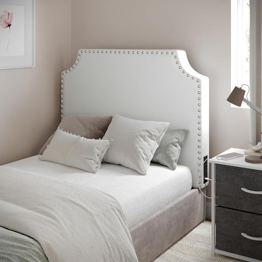 White studded upholstered headboard on a twin dorm bed with neutral bedding.