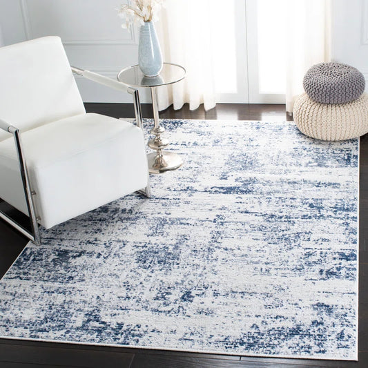 Ivory and navy abstract performance rug perfect for dorm living.  Styled with coastal decor and white seating.